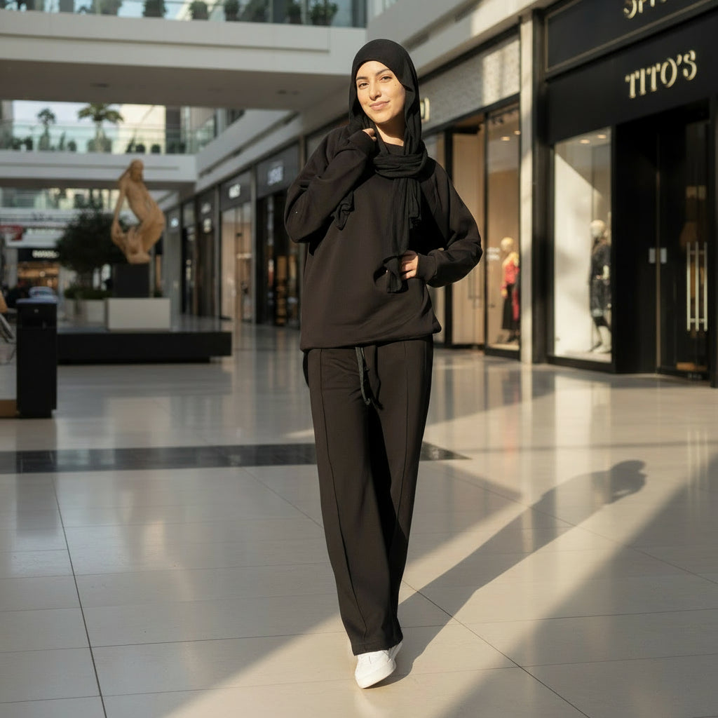 Person wearing a black outfit standing outdoors mall