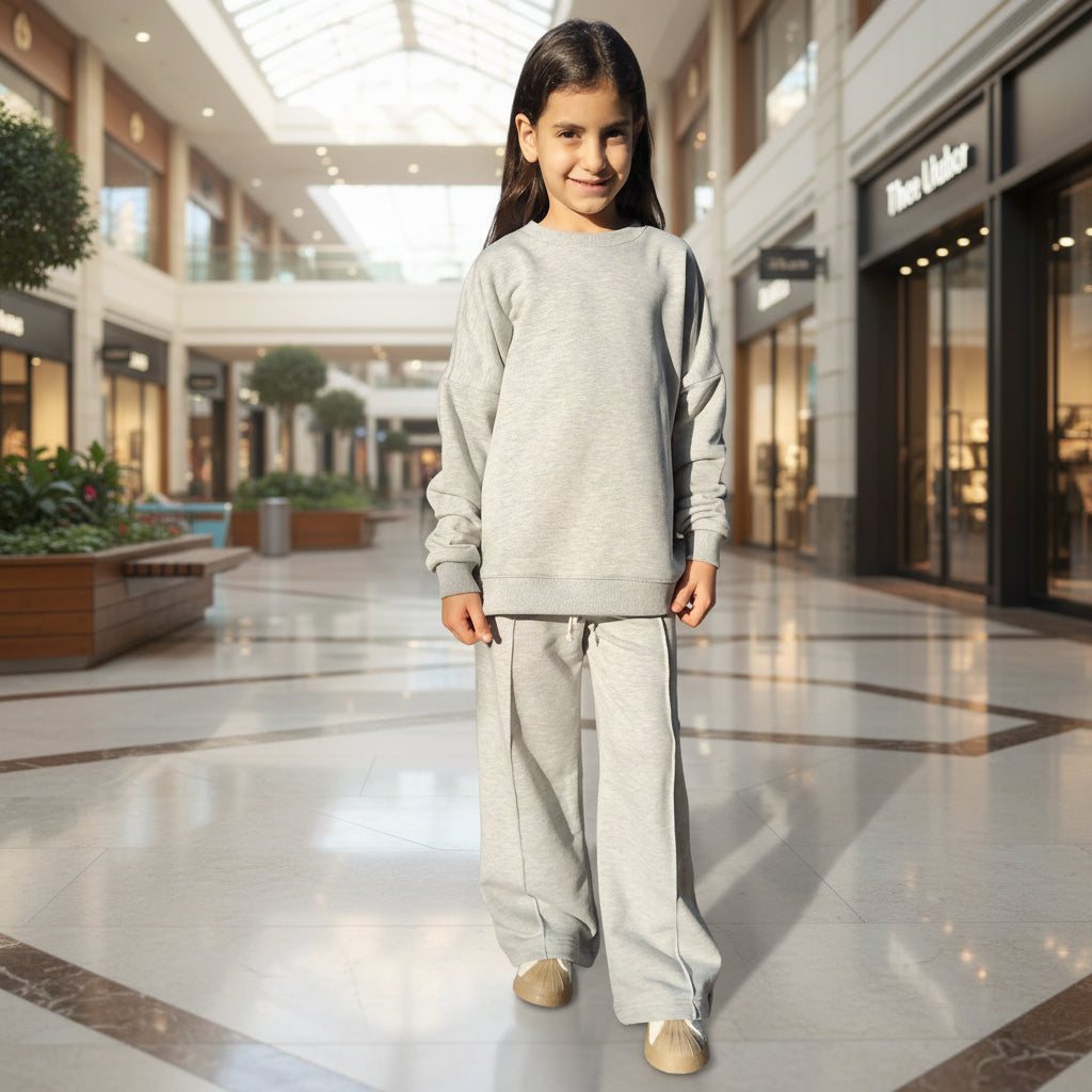 Person wearing a light gray outfit standing in open air mall