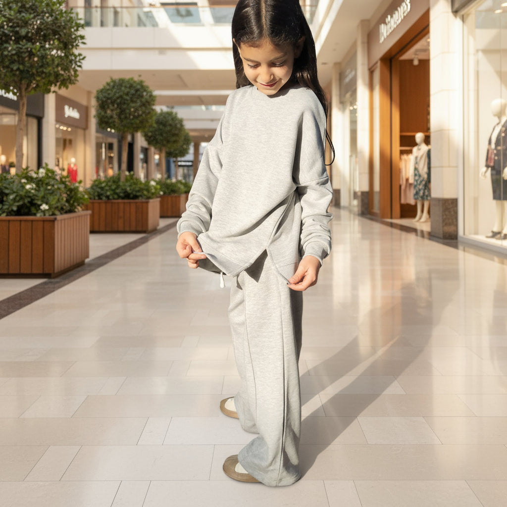 Person wearing a light gray outfit standing in open air mall