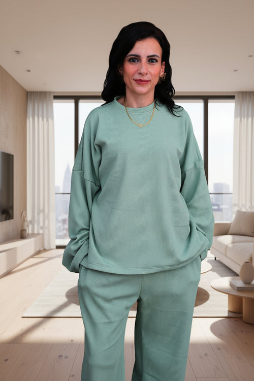 Woman wearing a green outfit on a black background