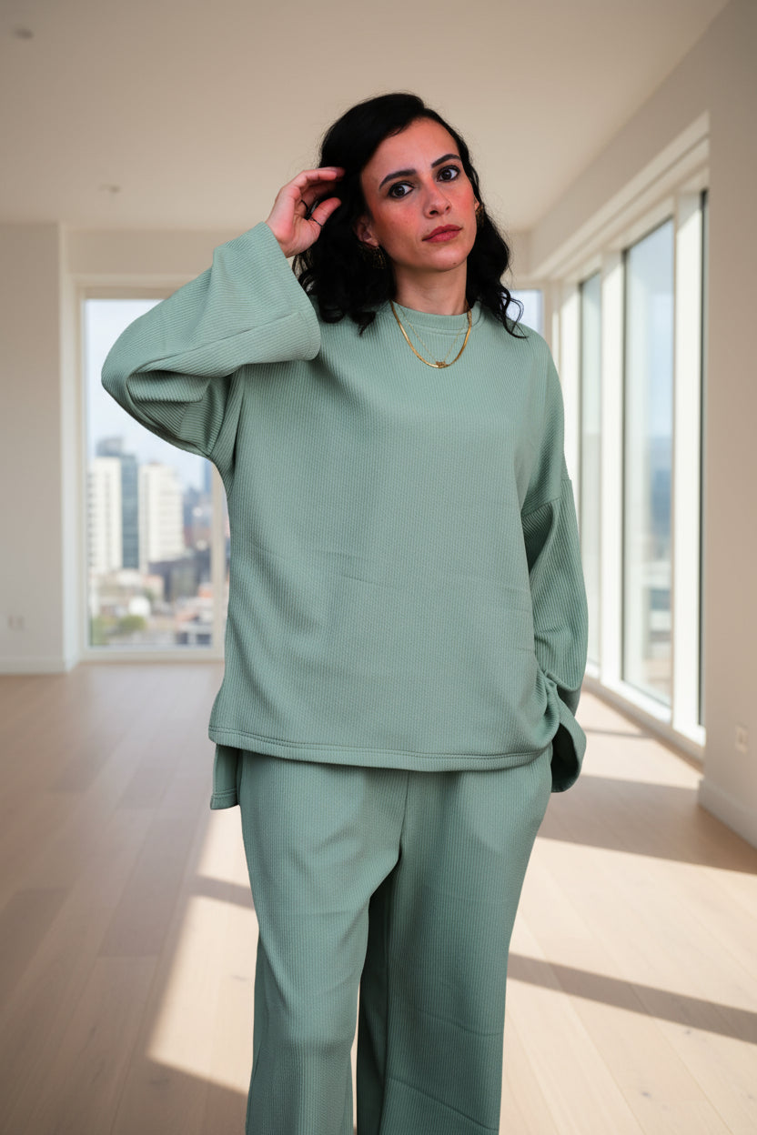 Woman wearing a light green outfit against a black background