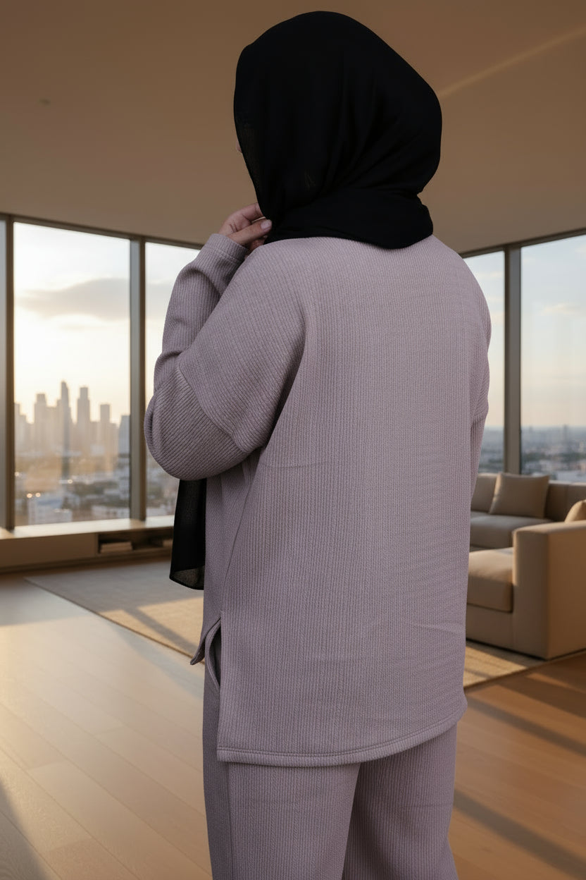 Person wearing a cafe outfit with a black hijab on a black background