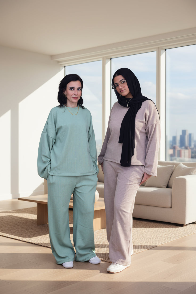 Two women wearing matching outfits in green and cafe on a black background