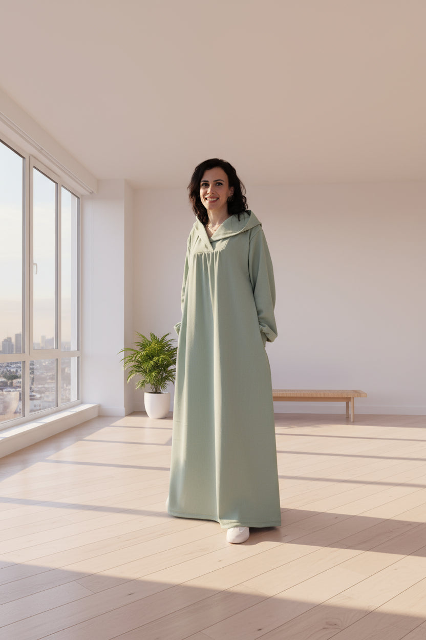 Person wearing a long green dress on a black background